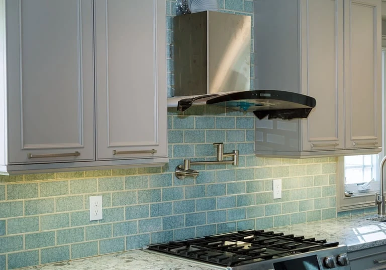 Kitchen cabinetry, cooktop and tile backsplash