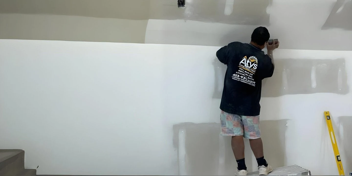 ATYS worker finishing an interior wall